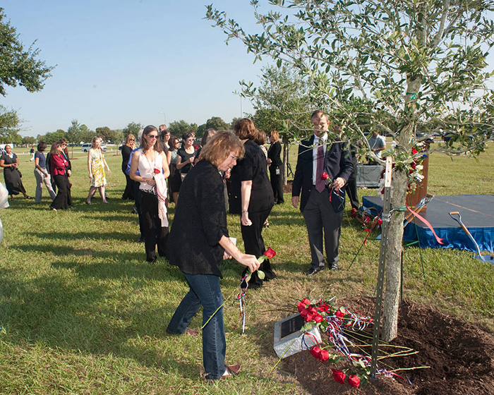 宇航员桑德拉·马格努斯在一棵为了纪念莎莉而种植的树旁放了一朵玫瑰。